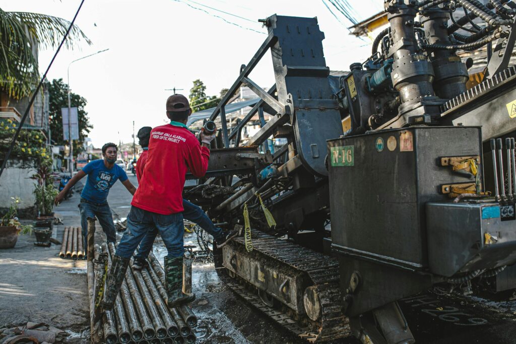 Urban scene of construction workers operating heavy machinery for street drilling.